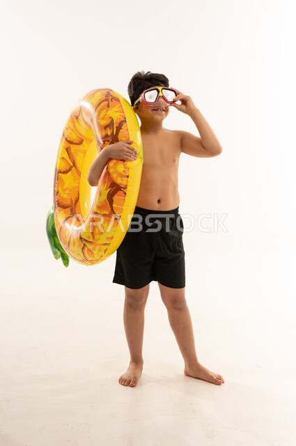 طفل سعودي بطوق سباحة ونظارات غوص في الاستوديو