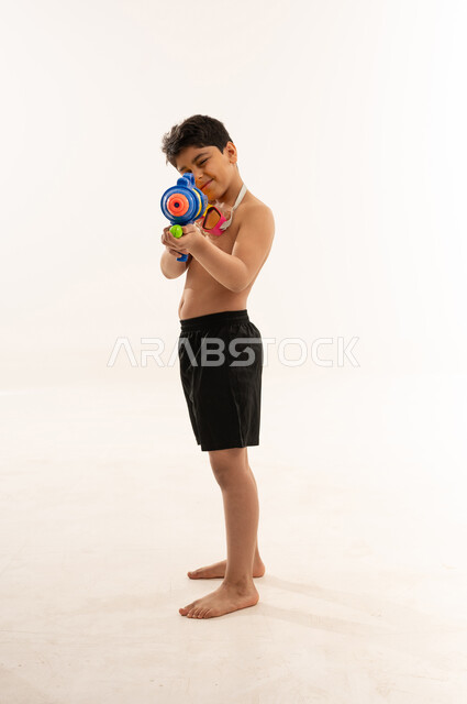 Saudi Boy Aiming Water Gun on White Background