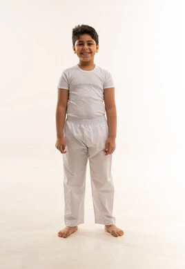 طفل عربي مبتسم بملابس بيضاء في الاستوديو