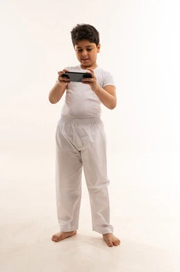 طفل عربي يستخدم الهاتف الذكي بخلفية بيضاء