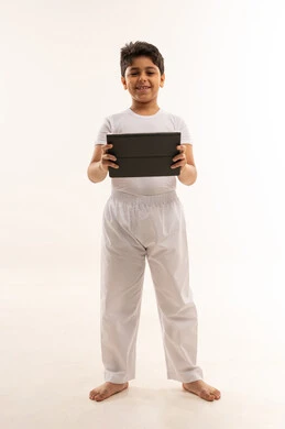 طفل عربي يحمل جهاز لوحي بخلفية بيضاء