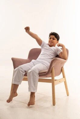 Arab Boy Stretching on Armchair Studio White Background