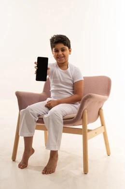 طفل عربي يمسك هاتف ذكي بشاشة فارغة