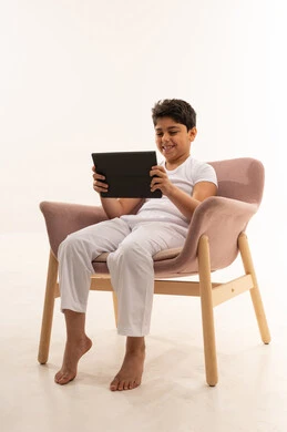 Arab Boy Using Tablet on Pink Chair White Background