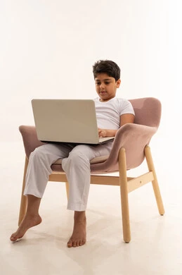 طفل سعودي يستخدم المحمول على كرسي عصري