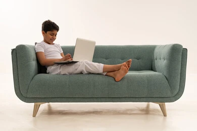 Arab Boy Using Laptop on Green Sofa White Background