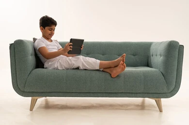 Arab Boy Using Tablet on Green Sofa