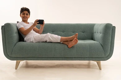Arab Boy Using Smartphone on Green Sofa