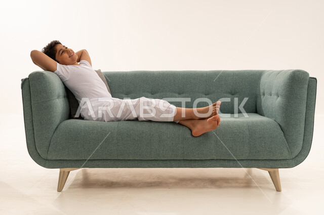 Arab Boy Relaxing on Green Modern Sofa