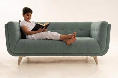 Saudi Boy Reading a Book on Modern Sofa
