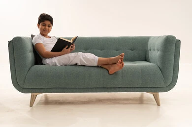Saudi Boy Reading Book on Modern Teal Sofa