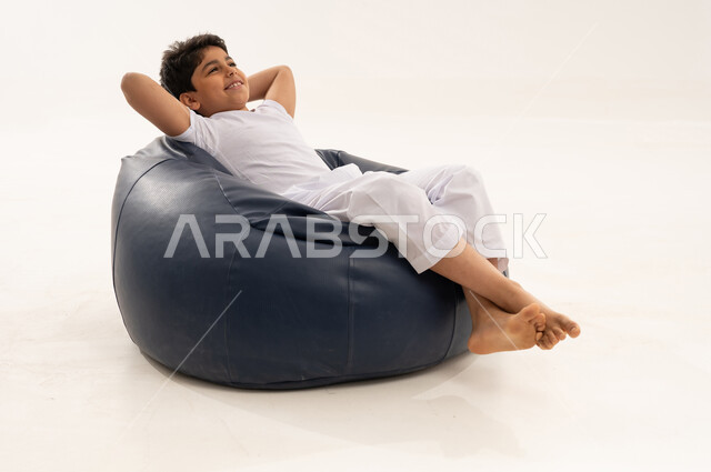 Saudi Boy Relaxing on Blue Beanbag Chair