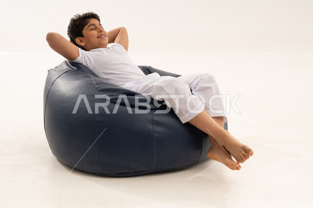 طفل سعودي يسترخي على كرسي بين باج في استوديو