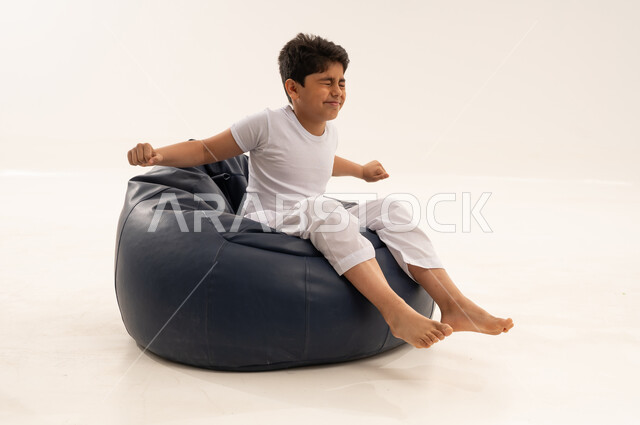 Arab Boy Stretching on Blue Bean Bag Chair