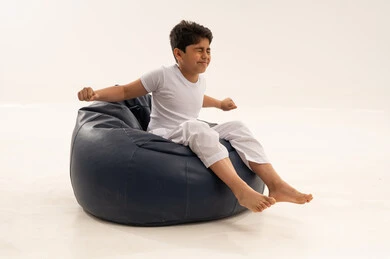 طفل عربي يتمدد على كرسي بين باج أزرق