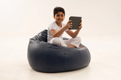 Arab Boy with Tablet on Blue Bean Bag Studio Shot