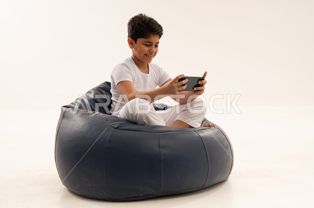 Arab Boy Playing Games on Smartphone in Studio