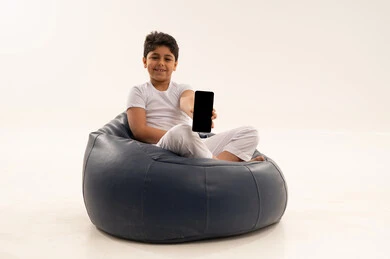 Arab Boy on Bean Bag Holding Blank Smartphone