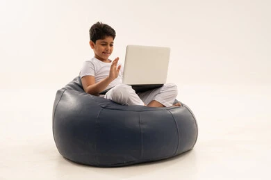 طفل عربي يستخدم المحمول على كرسي محشو