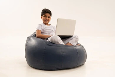 Arab Boy Using Laptop on Blue Beanbag Chair