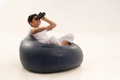 طفل سعودي يستخدم المنظار على مقعد مريح