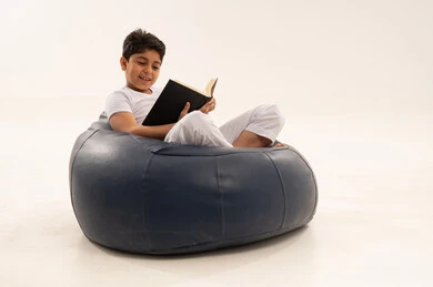 طفل عربي يقرأ كتاباً على مقعد بين باج