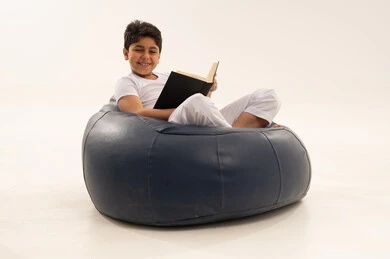 Arab Boy Reading Book on Blue Bean Bag Chair