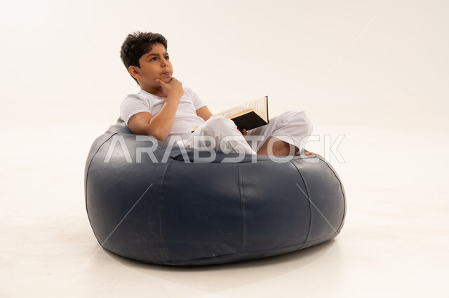 Arab Boy Thinking and Reading on Beanbag Chair