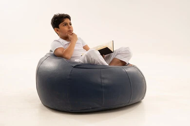 Arab Boy Thinking and Reading on Beanbag Chair