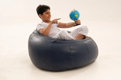 طفل عربي يحمل مجسم الكرة الأرضية في استوديو