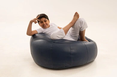 Middle Eastern Boy on Beanbag Making Victory Sign