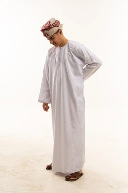 رجل عماني بالزي التقليدي يعاني من ألم أسفل الظهر