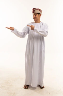 شاب عماني بالزي التقليدي يشير بيده داخل استوديو تصوير