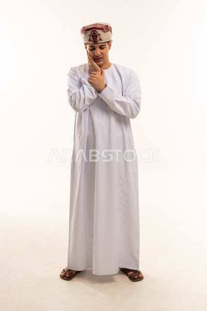 رجل عماني بالزي التقليدي يعاني من ألم الأسنان