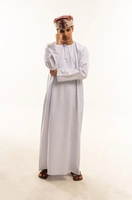 شاب عماني بالزي التقليدي أمام خلفية بيضاء