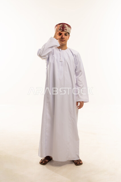 Omani Man in Traditional Dishdasha Making Hand Gesture