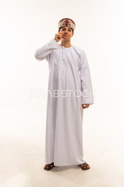 Omani Man in Traditional Dress Making Silence Gesture