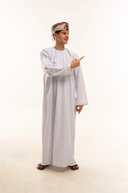 شاب عماني بالزي التقليدي يشير بيده في استوديو