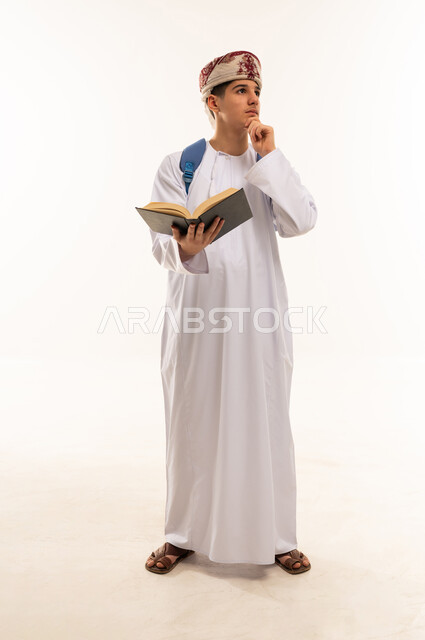 طالب عماني مع كتاب وحقيبة ظهر خلفية بيضاء
