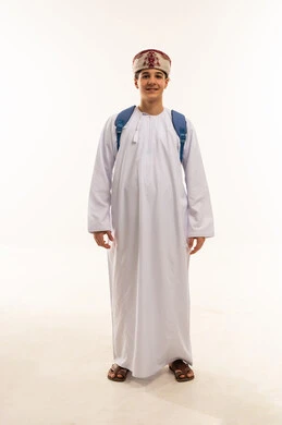 طالب عُماني بالزي التقليدي مع حقيبة ظهر