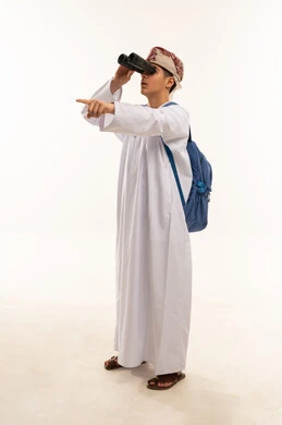 فتى عماني بالمنظار وحقيبة ظهر في استوديو احترافي