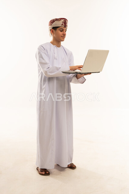 Omani Man in Traditional Dress Using Laptop