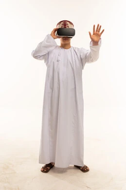 رجل عُماني يستخدم نظارات الواقع الافتراضي بخلفية بيضاء