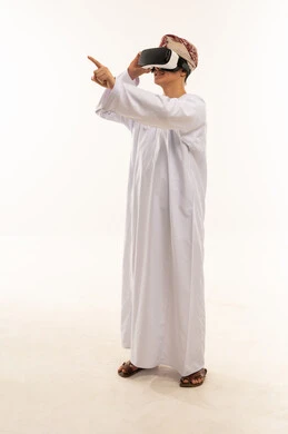 رجل عماني يرتدي سماعة واقع افتراضي بخلفية بيضاء