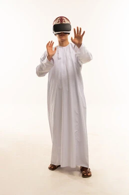 رجل عُماني يستخدم نظارة الواقع الافتراضي بالزي التقليدي