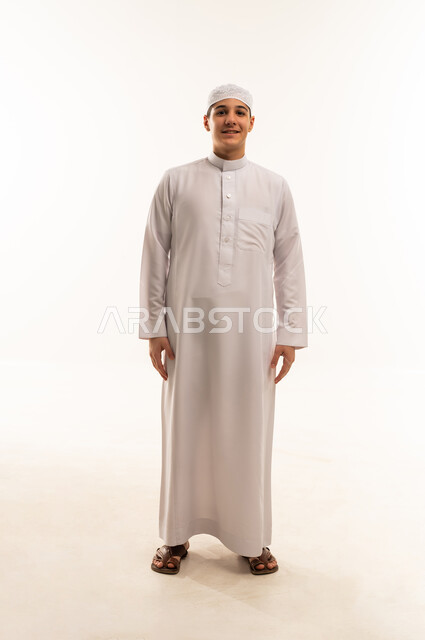شاب عربي مبتسم بالثوب الأبيض على خلفية بيضاء