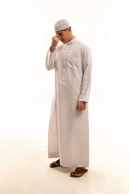 رجل عربي بالثوب التقليدي يشعر بالإرهاق خلفية بيضاء