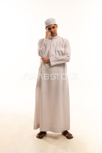 رجل عربي بالثوب الأبيض يفكر أمام خلفية بيضاء