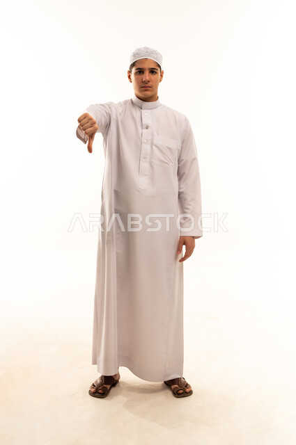 شاب سعودي بالثوب يرفع إبهامه للأسفل علامة الرفض