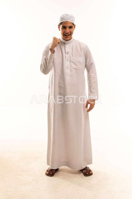 شاب عربي بالثوب الأبيض يقوم بإيماءة النصر